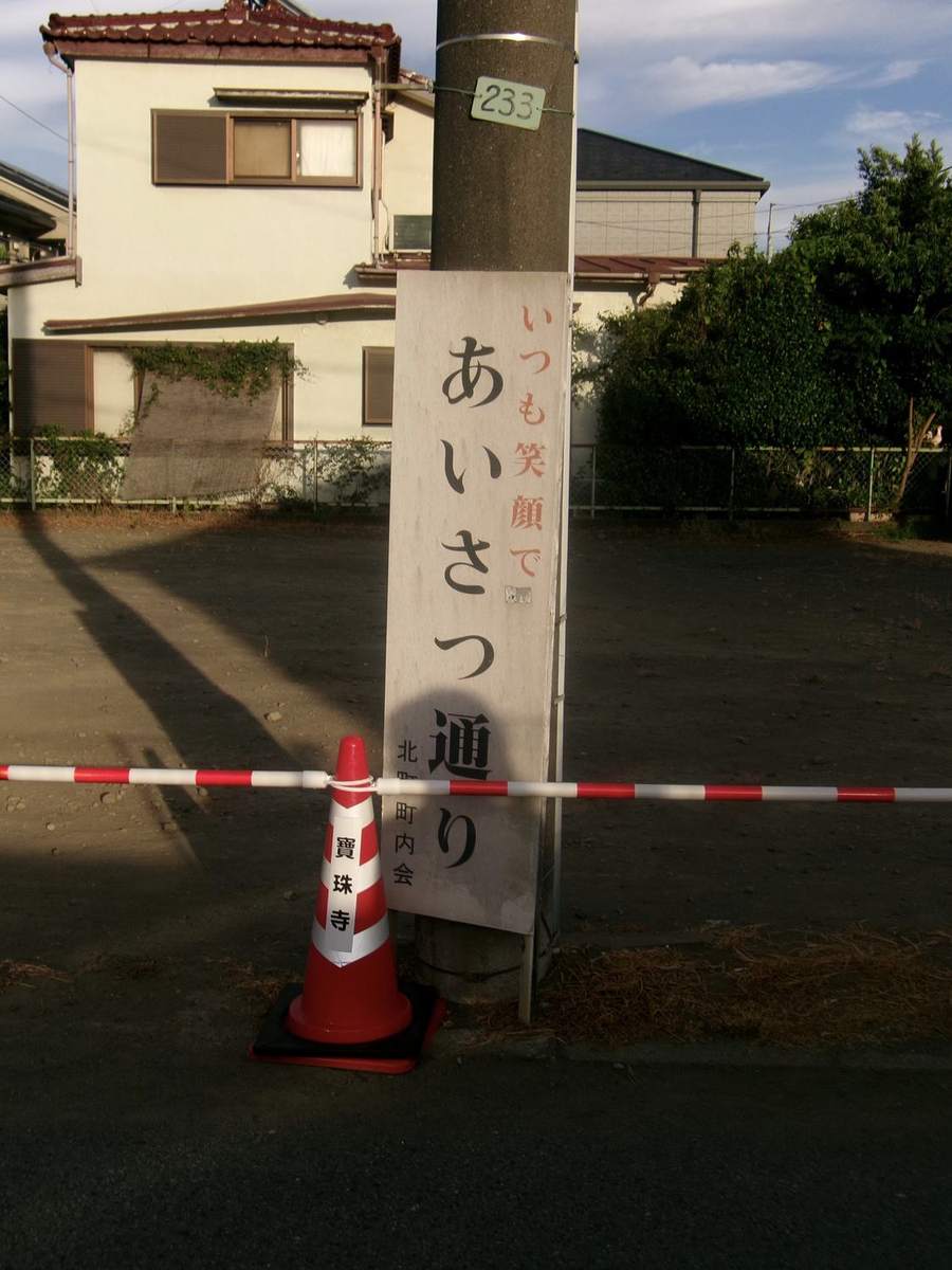 あいさつ通りの標柱と、通行止めのコーンと規制テープ