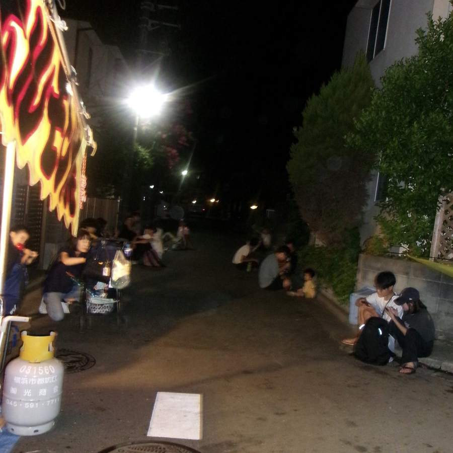 祭りの終わり、路地に座る人たち